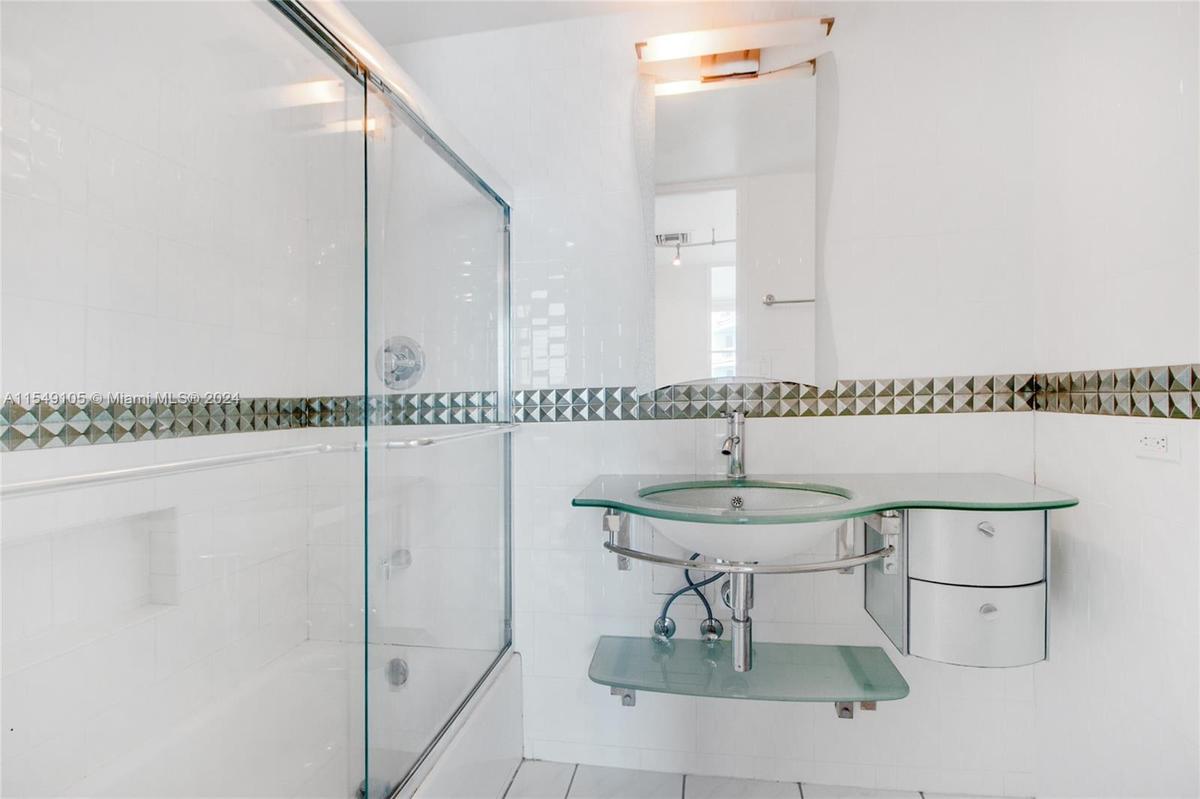 The Mid-Beach apartment has a full bathroom, pictured above, and a powder room.