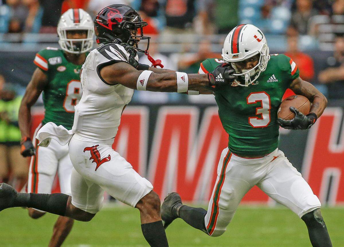 Miami Hurricanes wide receiver Mike Harley (3) runs after catching a pass in game against Louisville last season, with Cardinals defensive back Russ Yeast (3) offering resistance.