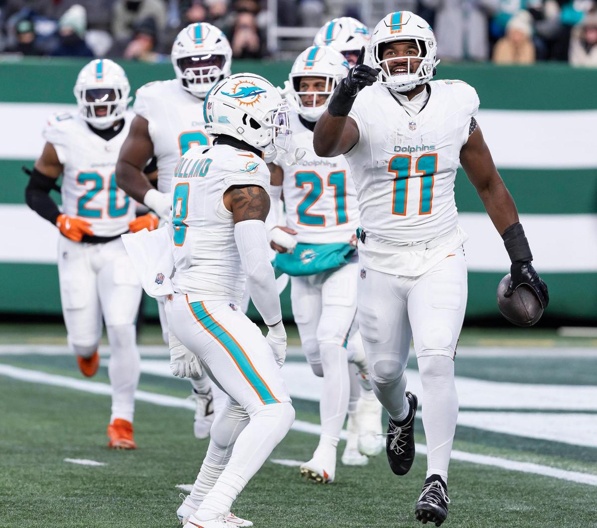 Miami Dolphins linebacker Tyrel Dodson (11) and safety Jevon Holland (8) celebrate after intercepting the ball from New York Jets quarterback Aaron Rodgers (8) in the first half of their NFL game at the MetLife Stadium on Sunday, Jan. 5, 2025, in East Rutherford, N.J.