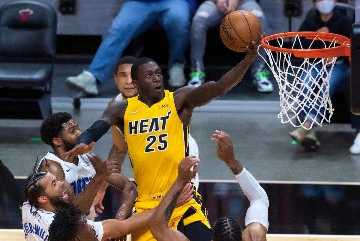 Miami Heat guard Kendrick Nunn (25) goes to the basket over Orlando Magic guard Michael Carter-Williams (7) and Magic center Khem Birch (24) in the second quarter of their game at AmericanAirlines Arena on Thursday, March 11, 2021.
