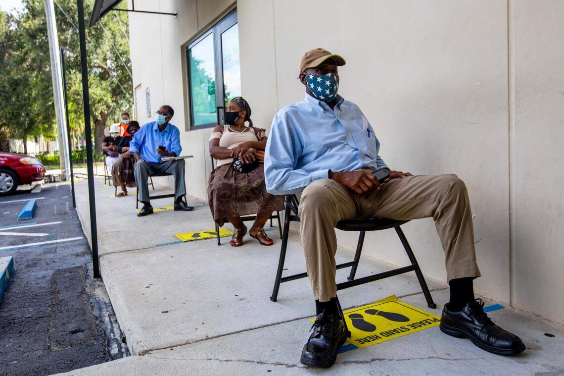 Perejona Lavenal is socially distanced while seated outside as he awaits his turn for assistance with unemployment at Sant La Haitian Neighborhood Center in North Miami, Florida on Tuesday, August 11, 2020.