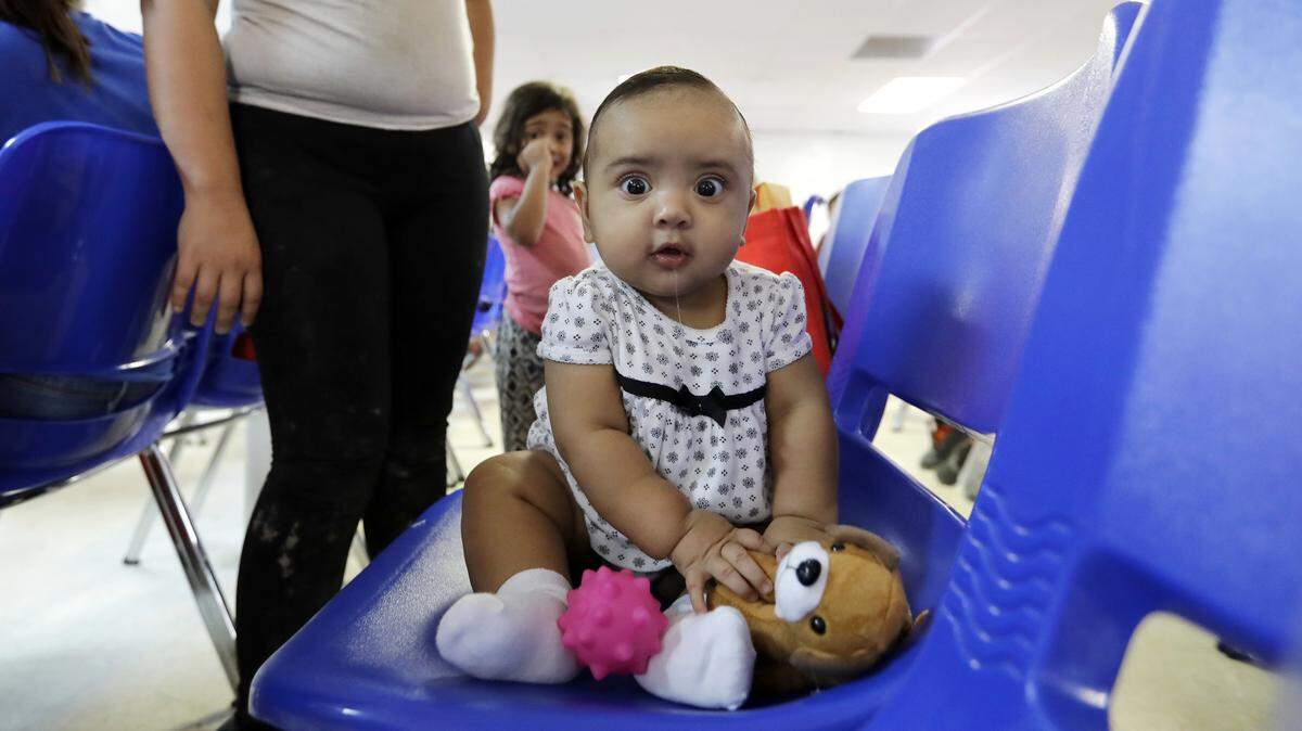An immigrant infant plays with a stuffed animal inside the Catholic Charities of the Rio Grande Valley on Saturday, June 23, in McAllen, Texas.