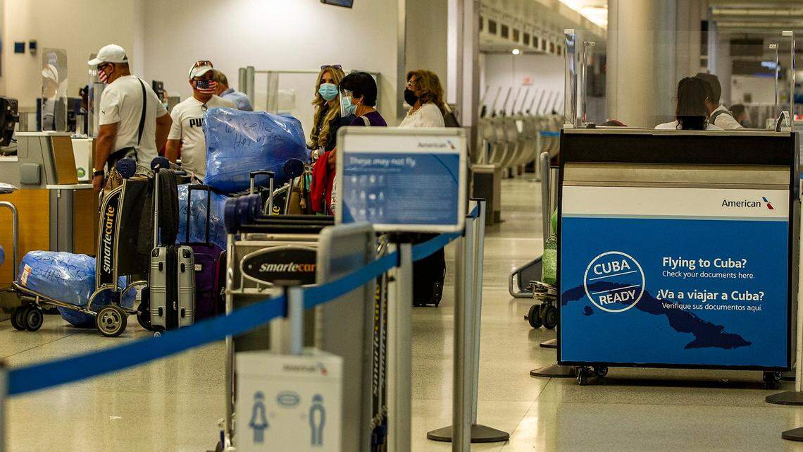 Cuban exiles line up to check in before boarding flights to the island on American Airlines at Miami International Airport on Friday, Nov. 20, 2020.