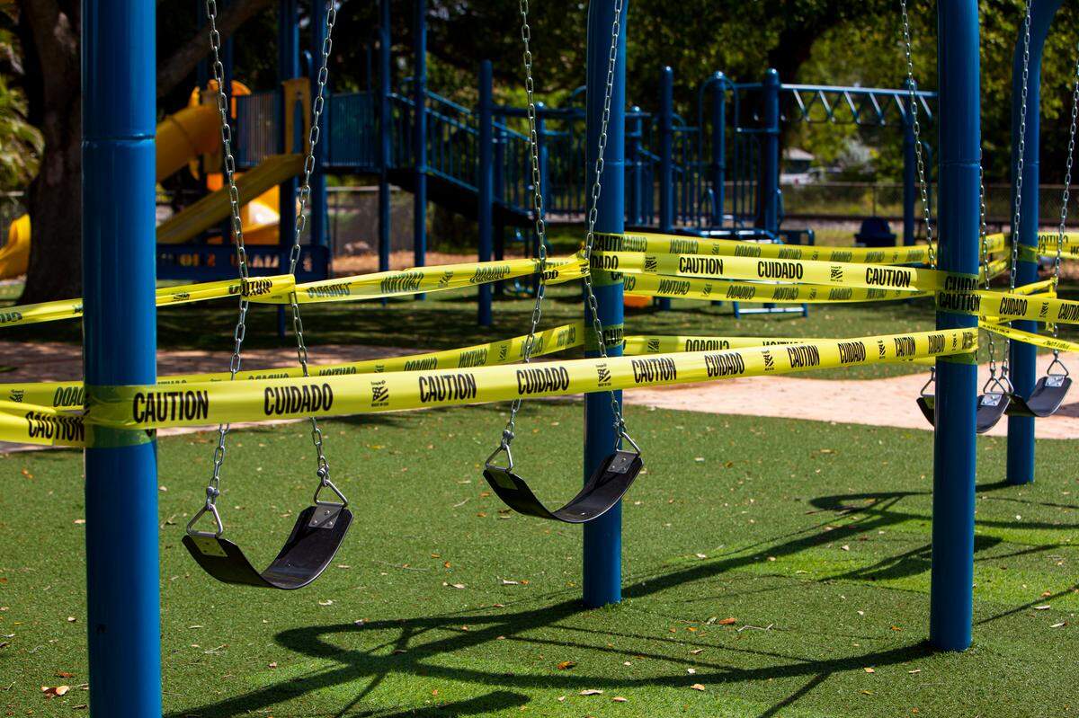 The Miami Shores playground gates are locked and its swings are wrapped in caution tape to keep children from playing as the village takes steps to reduce the spread of the coronavirus, April 1, 2020.