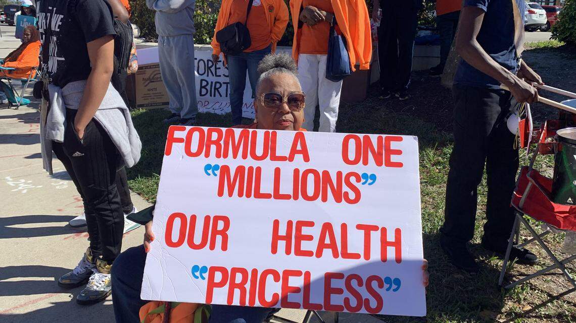 Former Miami-Dade County Commissioner Betty Ferguson holds a sign at a protest outside the Super Bowl on Feb. 2, 2020.
