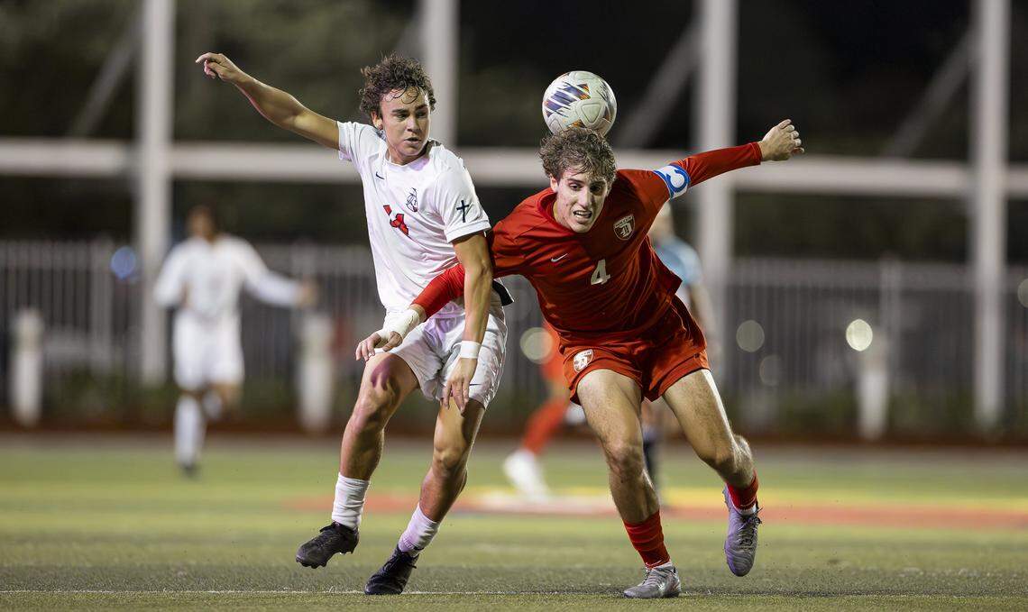 Columbus Explorers Ezequiel Bartra (14) and Doral Academy Firebirds Manuel Lazzaro (4) compete for the ball in the second half of their Region 4-7A semifinal playoff high school soccer game at Doral Academy on Thursday, Feb. 12, 2026, in Doral, Fla.