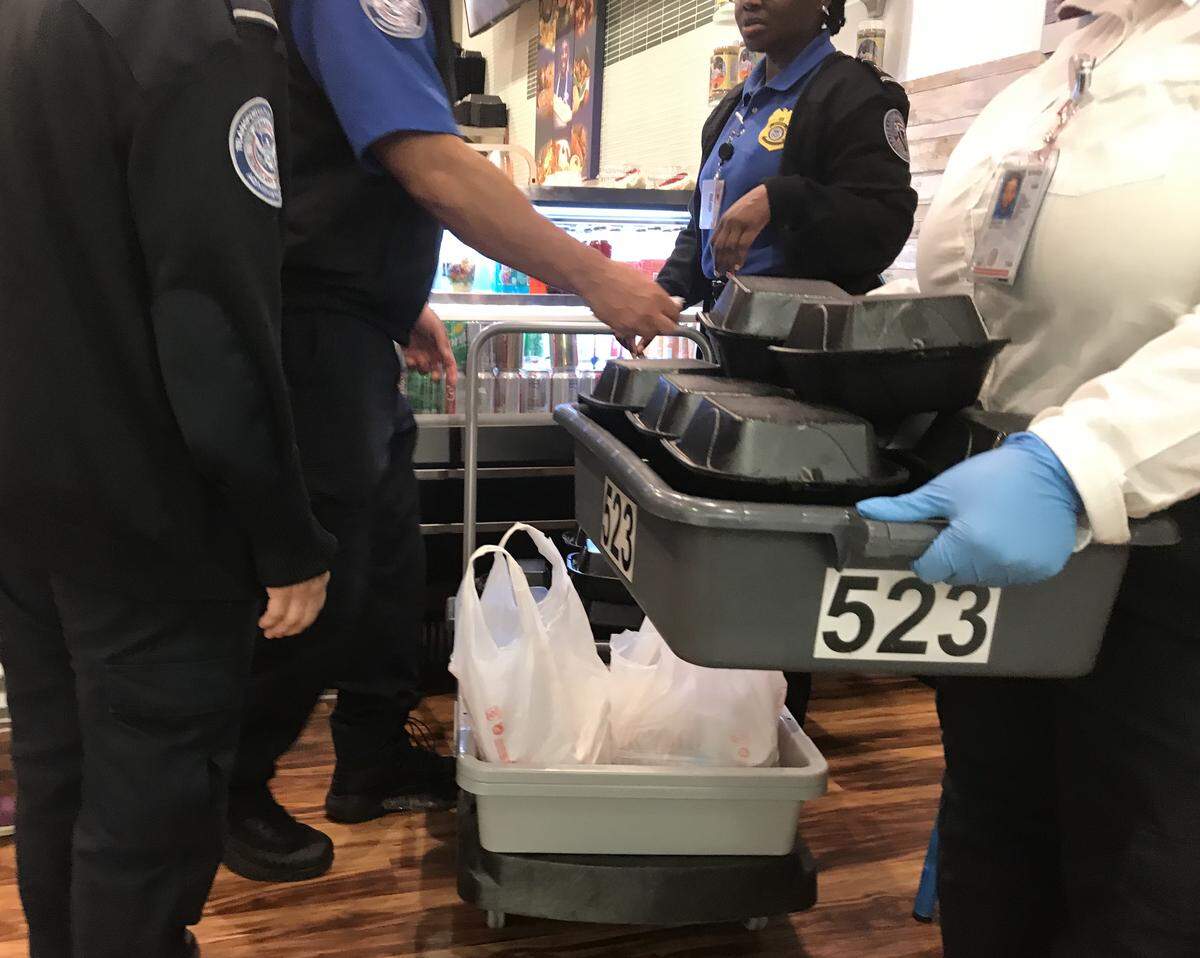 TSA workers at Miami International Airport load up free meals donated by the Chef Créole restaurant for federal employees working without pay during the shutdown. This was the first day of the giveaway, on Monday, Jan. 14, 2019, and the restaurant had distributed more than 300 free meals at the airport.