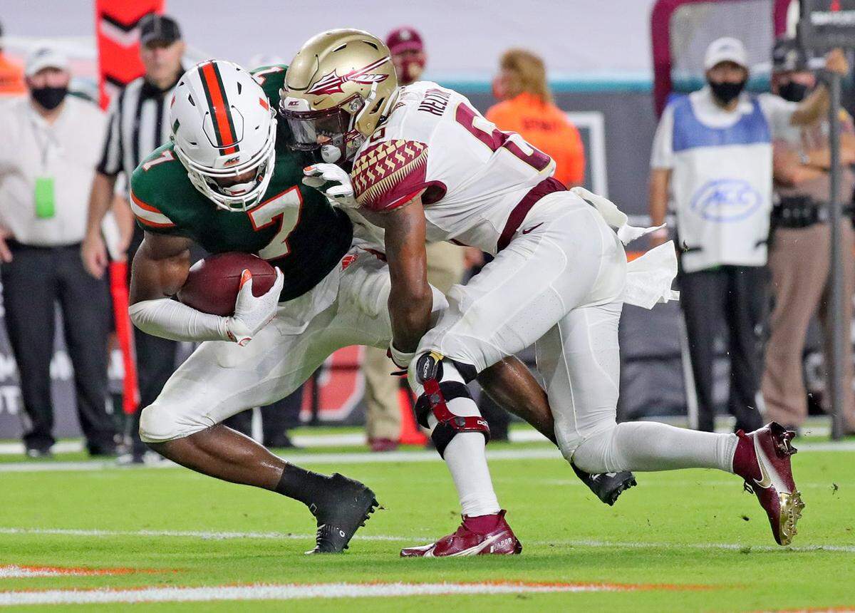 UM’s cornerback Al Blades, Jr. (7) intercepts the ball in the second half as FSU’s LaÕDamian Webb (8) tackles him as the University of Miami host Florida State University Seminoles at Hard Rock Stadium in Miami Gardens on Saturday, September 26, 2020.