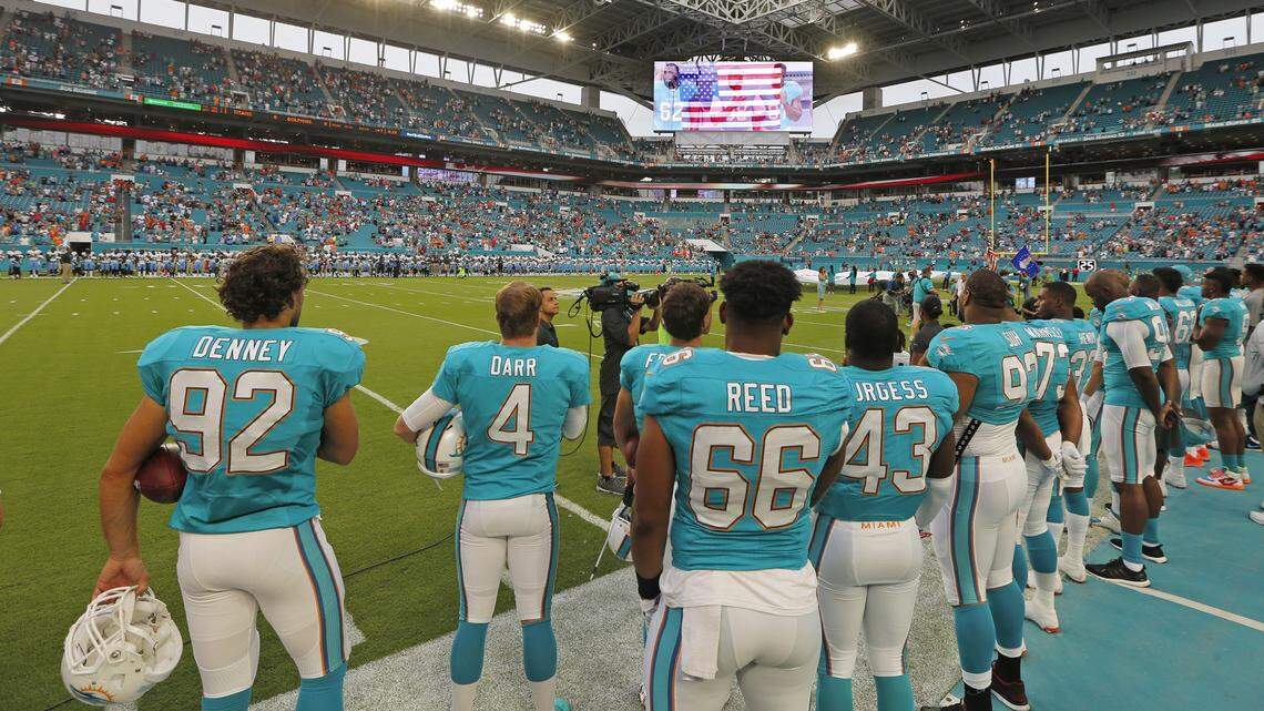The team stands for the national anthem as the Miami Dolphins host the Tennessee Titans at Hard Rock Stadium on September 1, 2016.