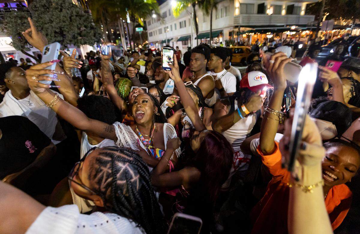 A crowd of people dance on Ocean Drive during spring break on Saturday, March 11, 2023, in Miami Beach, Fla.