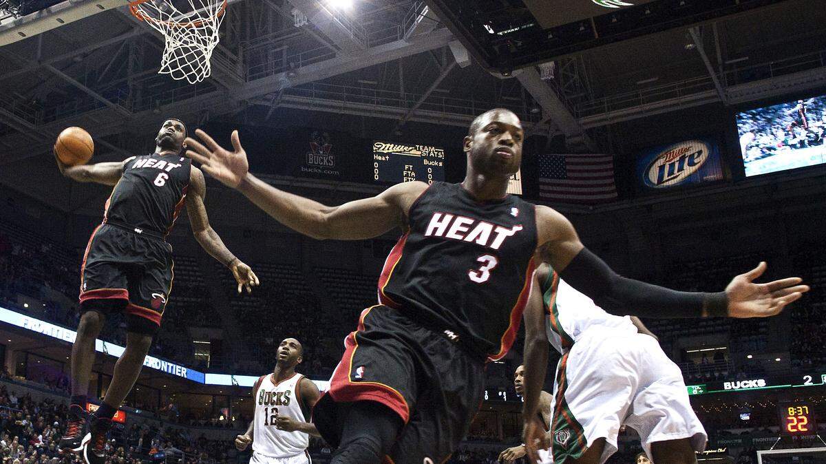 Miami Heat's Dwyane Wade (3) reacts as teammate LeBron James (6) goes up for a dunk during the first half of an NBA game against the Milwaukee Bucks on December 6, 2010.