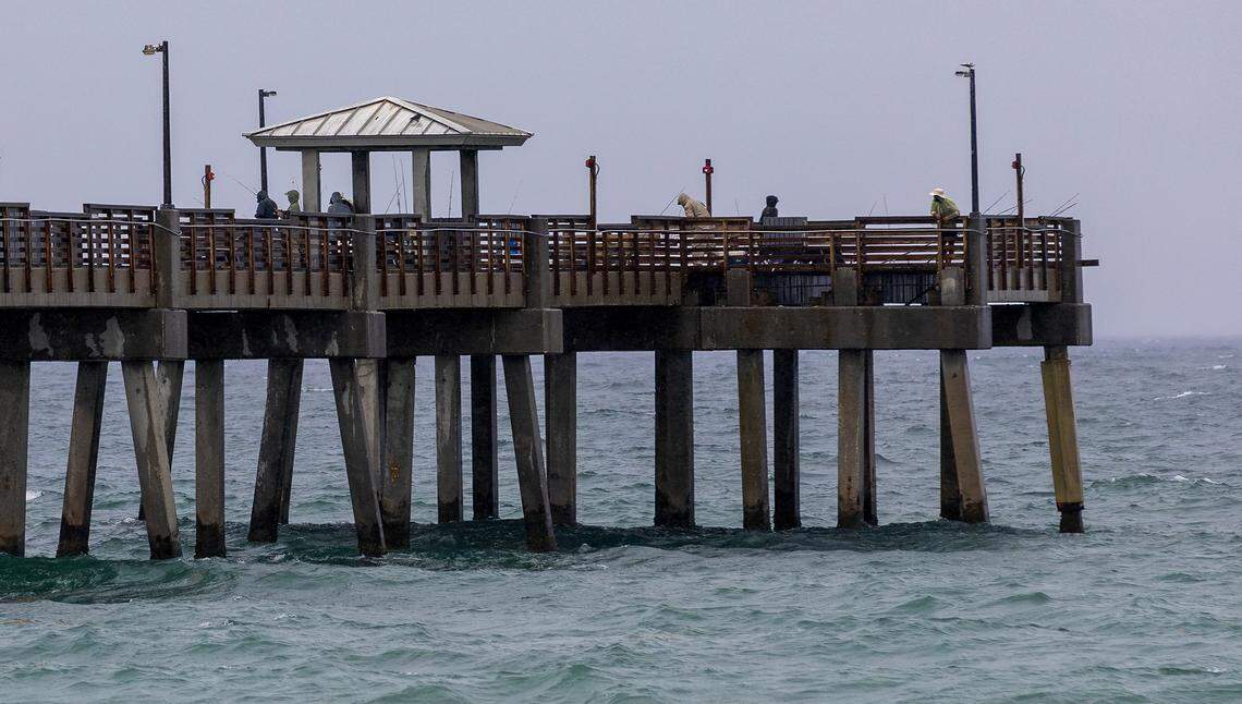 Anglers fish in the rain at Dania Beach Pier on Monday, May 12, 2025, in Dania Beach, Florida. The National Weather Service in Miami forecasts widespread showers and thunderstorms, with a 90% chance of rain and 1 to 3 inches expected by Tuesday morning.