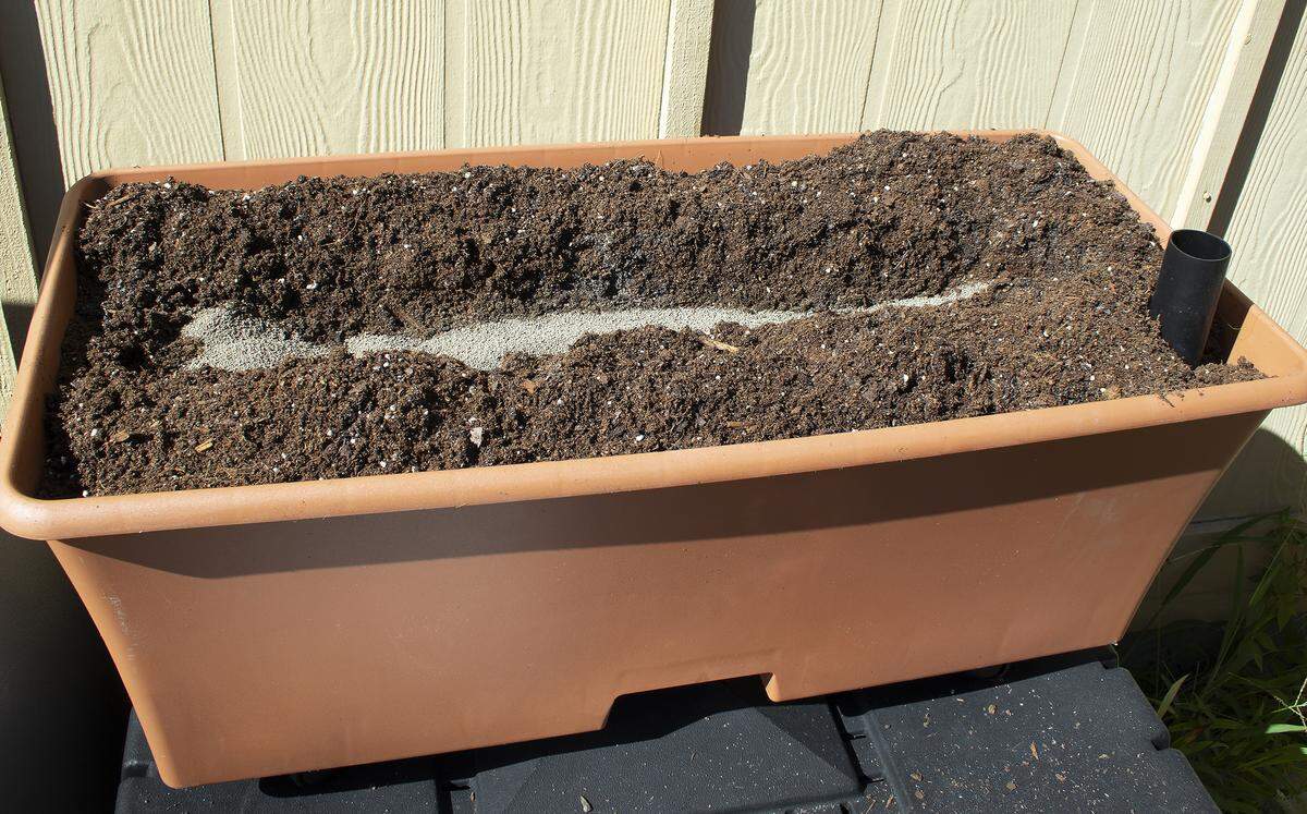 An EarthBox readied with soil and included fertilizer. Dolomite has also been added.