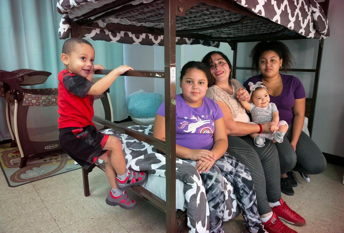 Lorena Torrente with her four children, from left, Rafael, 3, Noelis, 10, Melissa, 9 months old, and Noelia, 15, on a bunk bed at a temporary housing shelter operated by the Miami Rescue Mission. The family stayed at the shelter for a short time after Torrente became homeless during the pandemic after losing her income. The family is at another temporary home and is in need of permanent housing. The children are also in need of clothing and school supplies.