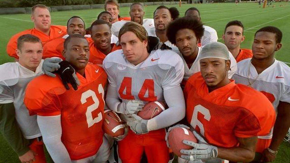 UM’s senior football class of 2000 gathers on the field for practice. Linebacker Dan Morgan (44), nominated for the 2019 class of the College Football Hall of Fame, is in the center.