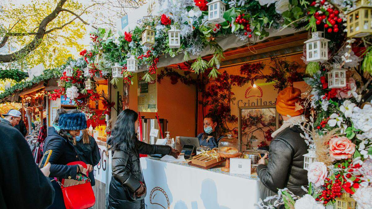 Los clientes echan un vistazo a la mercancía de un vendedor en uno de los mercados Urbanspace en Columbus Circle, Nueva York.