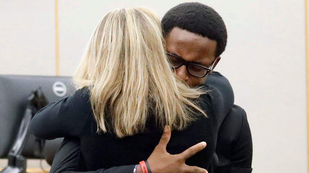 Brandt Jean hugs Amber Guyger, the former Dallas police officer who shot and killed his brother, at her sentencing hearing.