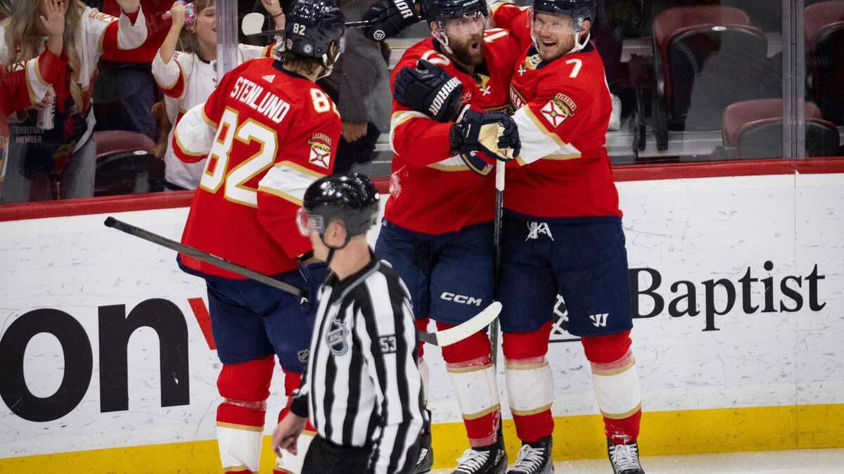 Florida Panthers Jonah Gadjovich (12) celebrates his first goal of the season with defenseman Dmitry Kulikov (7) during the third period of a hockey game on Wednesday, Jan. 24, 2024, at Amerant Bank Arena in Sunrise, Fla. The Florida Panthers beat the Arizona Coyotes 6-2.