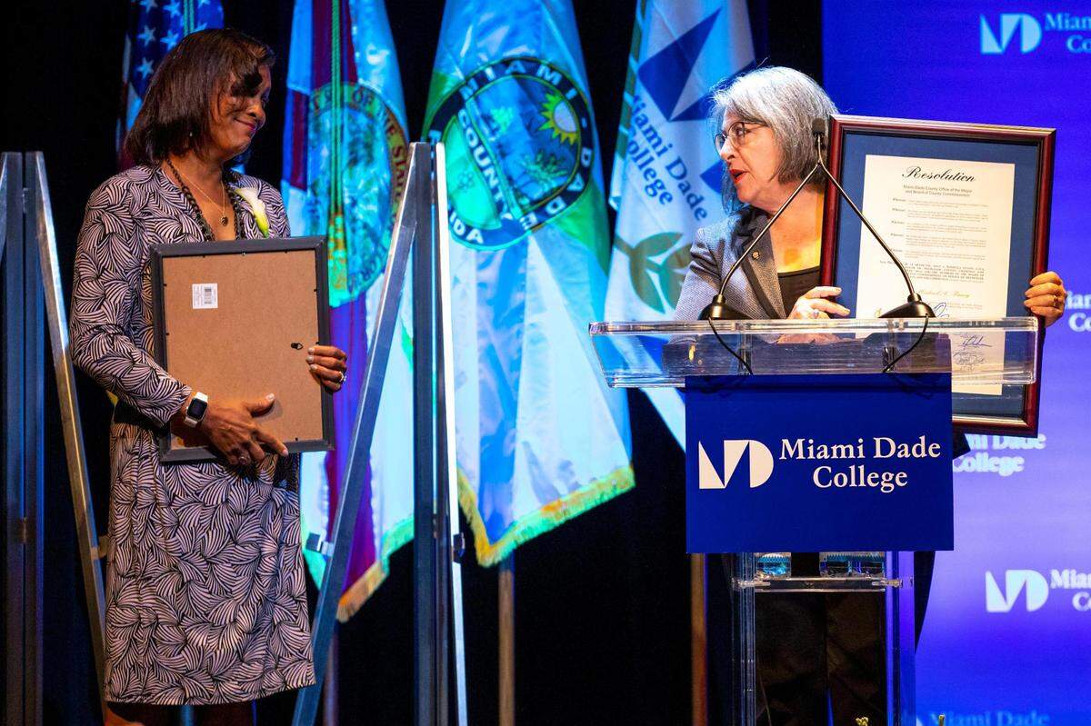 Daniella Levine Cava, mayor of Miami-Dade County, presents Gina Finney with a County Resolution commemorating her husband’s impact on the community, during a memorial service for Michael A. Finney, president and CEO of the Miami-Dade Beacon Council, at Miami Dade College, Wolfson Campus in Miami on Monday, April 25, 2022.