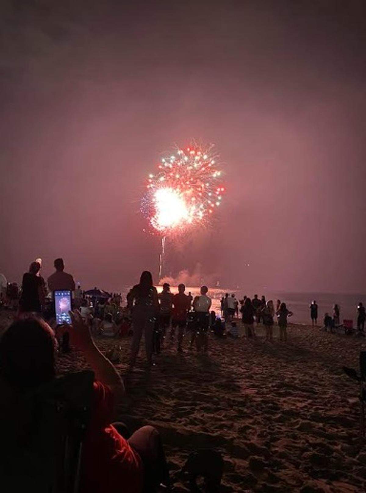 People enjoy the fireworks on July 4, 2025, near the Hollywood Beach Broadwalk. (Michael Butler/mbutler@miamiherald.com)