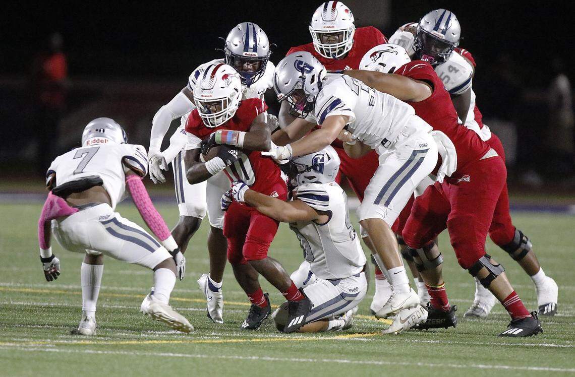 Chaminade-Madonna wide receiver Duane Thomas (10) is tackled by Gulliver Prep defenders during the football game on Friday, October 15, 2021 at Chaminade-Madonna College Preparatory School in Hollywood