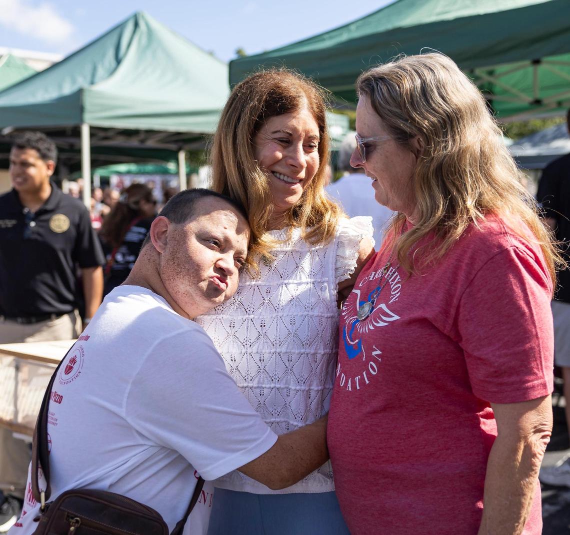 Corey Hixon, the son of Christopher Hixon, hugs Linda Beigel Schulman, the mother of Scott Beigel, as his mother, Debra Hixon looks on during the ‘Forever in Our Hearts’ commemoration event outside of the Eagles’ Haven Wellness Center on Friday, Feb. 14, 2025, in Coral Springs, Fla. The event aims to honor the 17 lives lost during the Marjory Stoneman Douglas High School shooting in 2018 and their families.