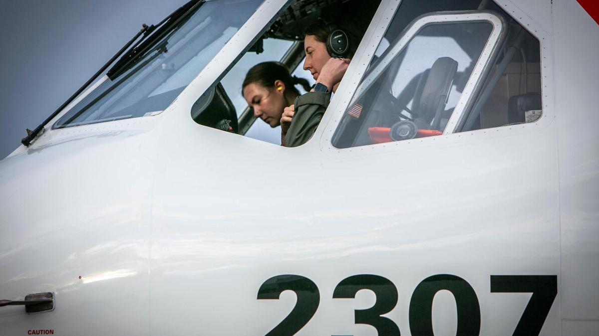 Lieutenant Katrina E. Prout, foreground and Lt. j.g. Hannah Boyce prepare to take a US Coast Guard HC-144 Ocean Sentry on a reconnaissance flight over the Florida straights and the Bahamas in April 2022.