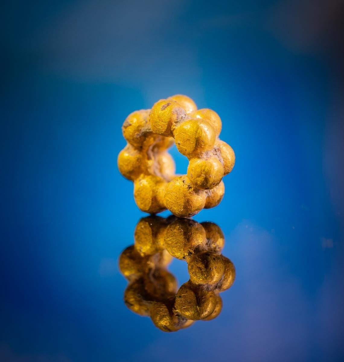 A close-up photo of the gold bead.