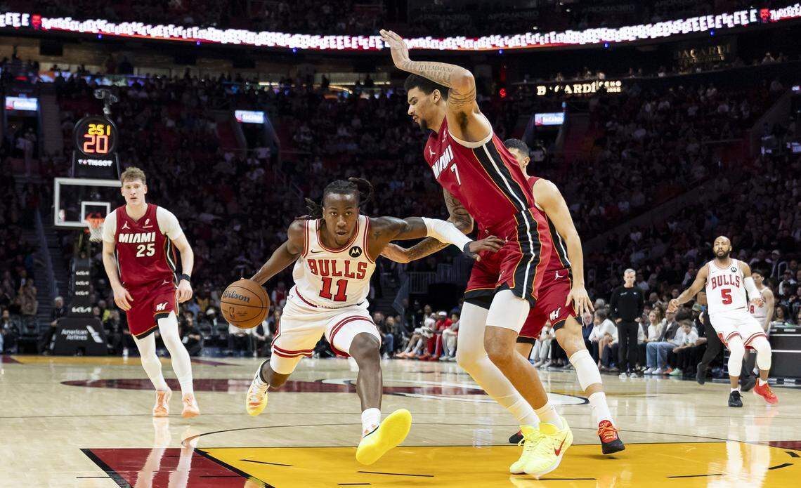 Chicago Bulls guard Ayo Dosunmu (11) drives the ball as Miami Heat center Kel'el Ware (7) defends in the first half of their NBA game at the Kaseya Center on Saturday, Jan. 31, 2026, in Miami.