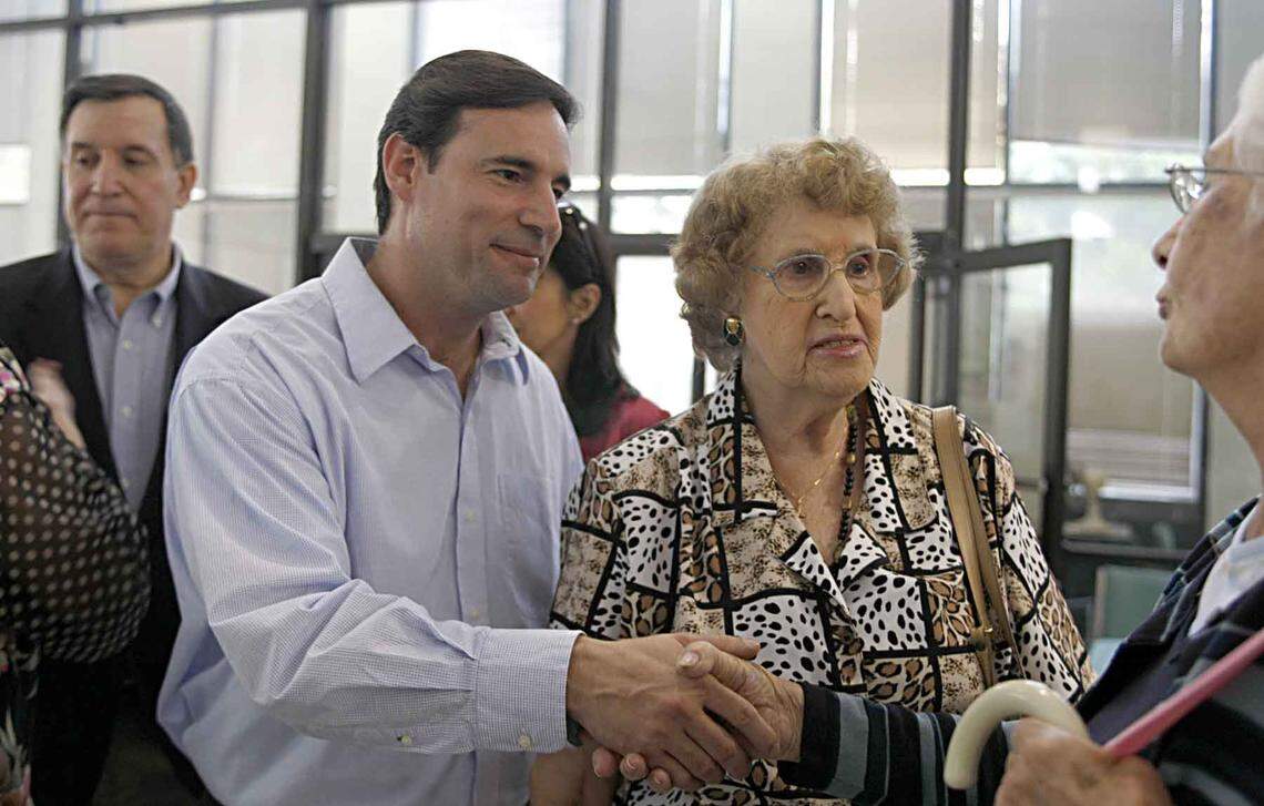 Former Miami Mayor Joe Carollo (far left) joined his mother, Graciella Carollo (center right), as she thanked supporters of her son Frank Carollo (center left), recently elected to the City of Miami commission, during a visit to the Little Havana Activities Center on Nov. 20, 2009.