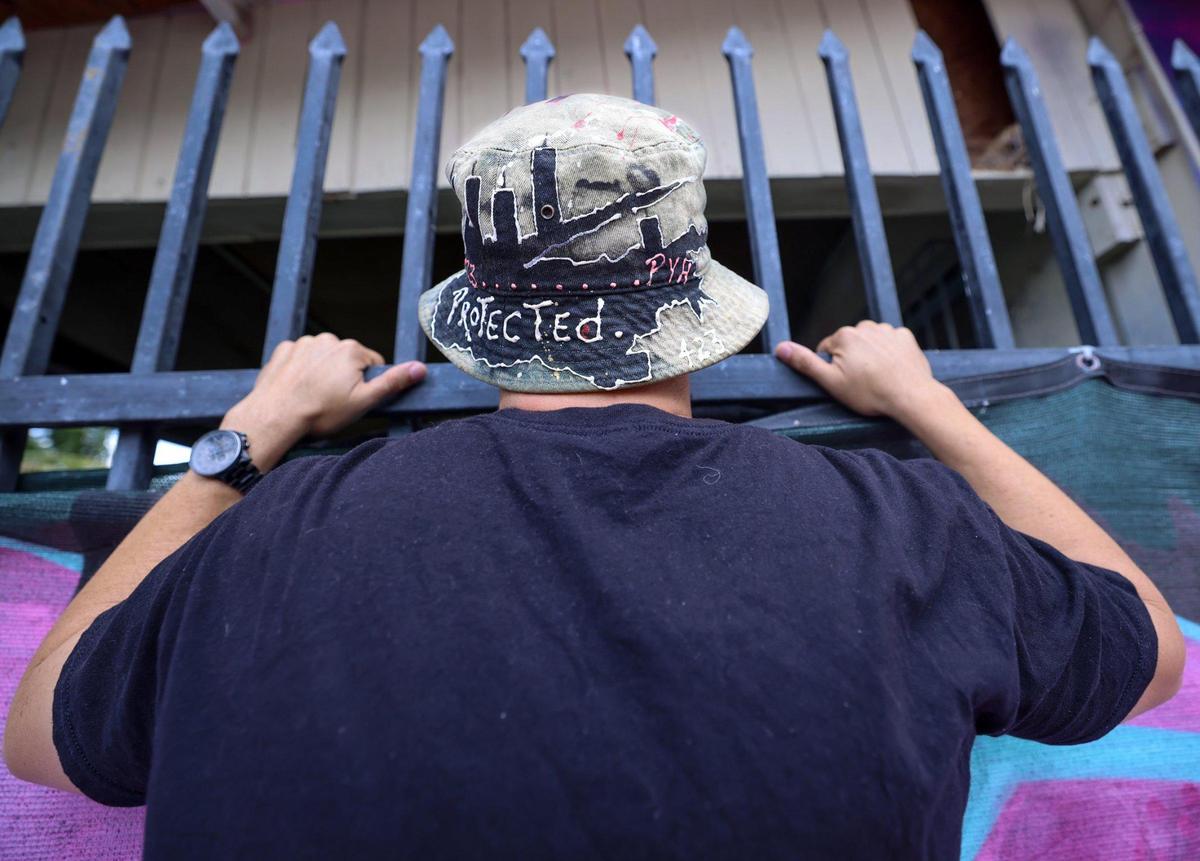 Fabian Martinez peeks over the exterior wall of Esquina de Abuela as he reflects on the loss of the community space in Miami on Tuesday, April 29, 2025.