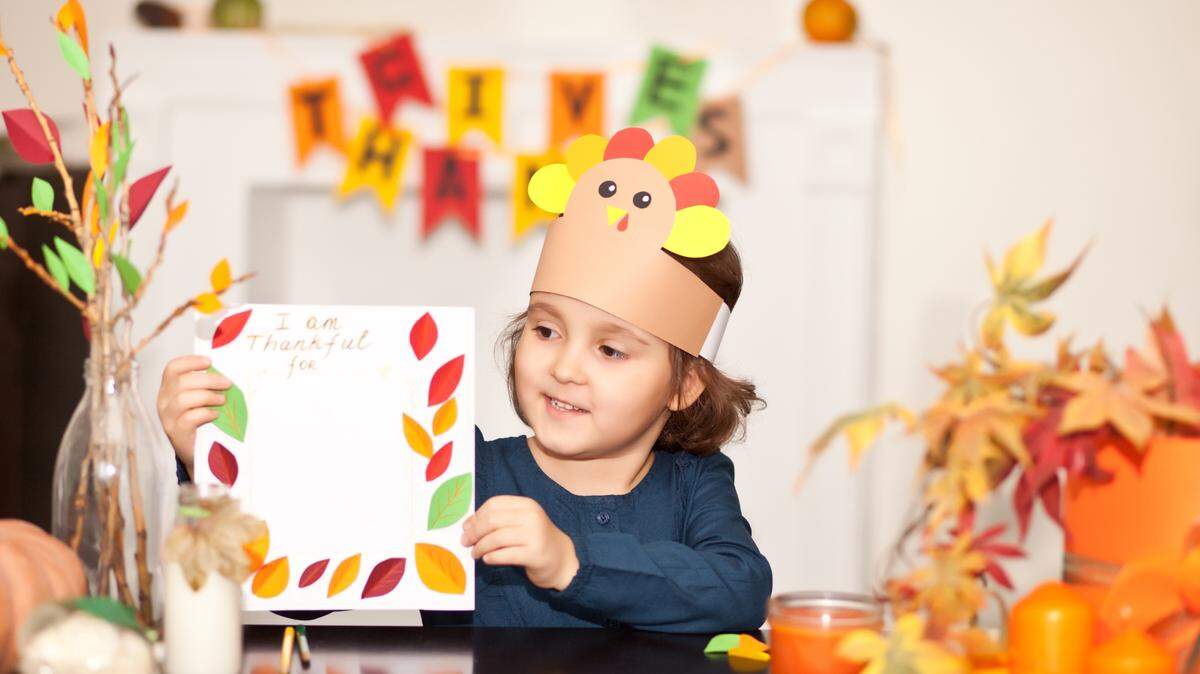 young child making thanksgiving art