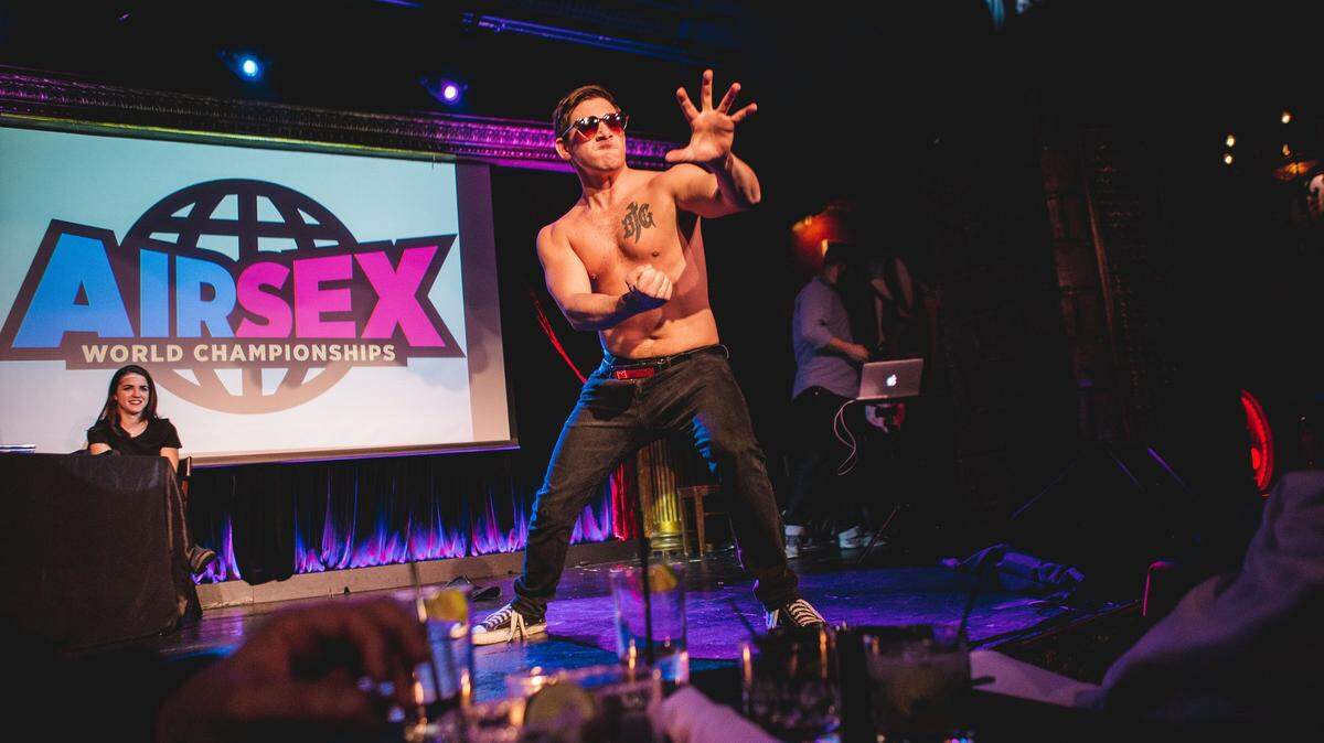 A contestant in the Air Sex Championships acts out making the beast with two backs with just the one back.