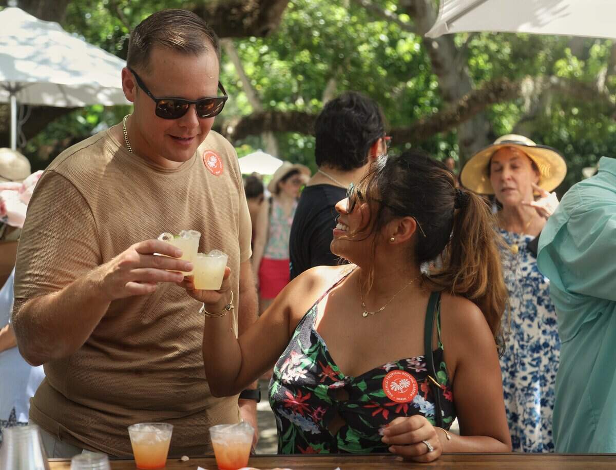 Robert Scribner and wife Maribel Moreno try a mango cocktail during the Mango Festival at Fairchild Tropical Botanic Garden.