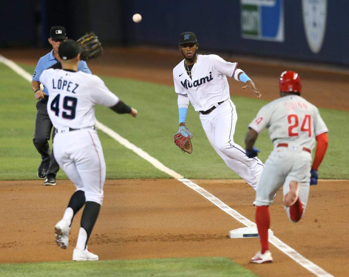 Miami Marlins Lewin Diaz (68) tosses the ball to starting pitcher Pablo Lopez (49) to tag out Philadelphia Phillies center fielder Roman Quinn (24) in the first inning as the Miami Marlins play the Philadelphia Phillies during a baseball game at loanDepot park on Thursday, May 27, 2021.