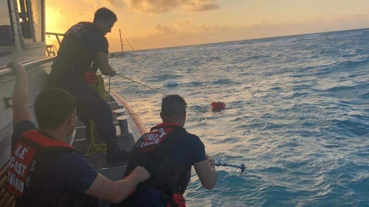 U.S. Coast Guardsmen assigned to a 45-foot Response Boat-Medium based at Coast Guard Station Islamorada pull a man toward the boat during a rescue near Key Largo, Florida, Feb. 21, 2019.