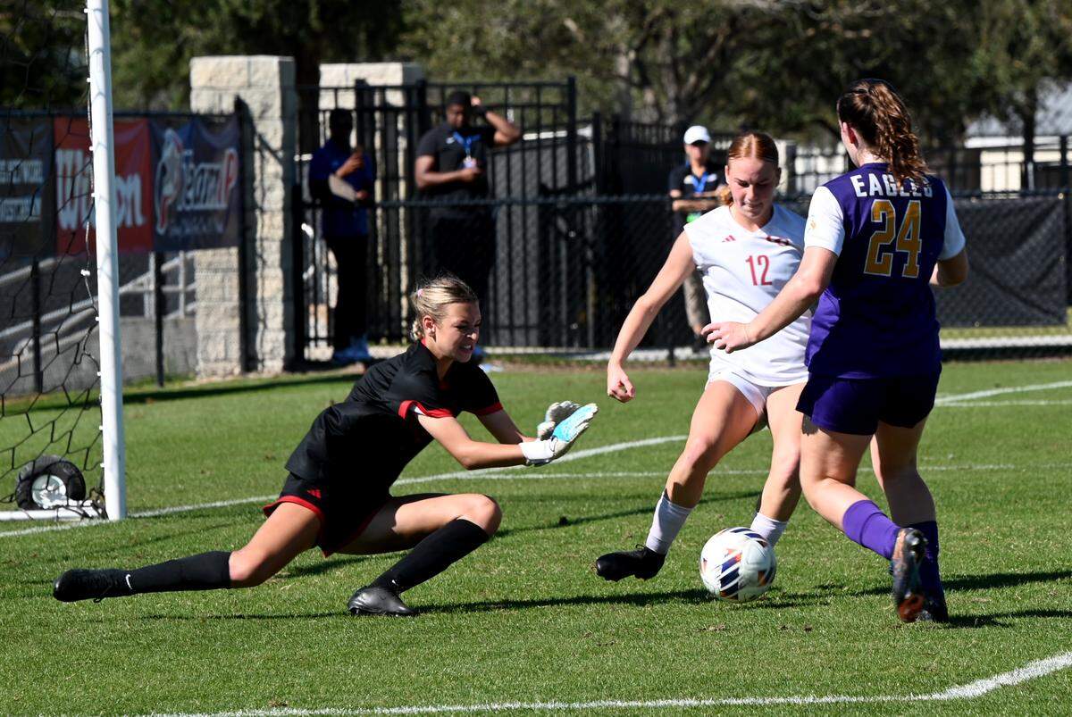 Cardinal Gibbons goalkeeper Kennedy McCausland makes a save against Montverde Academy during the Class 3A girls soccer state championship game on Saturday at Lake Myrtle Soccer Complex in Auburndale.