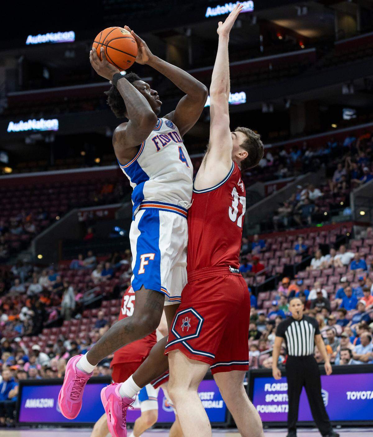 Florida Gators forward Tyrese Samuel (4) tries to score as Richmond Spiders center Neal Quinn (32) defends in the second half of their Orange Bowl Basketball Classic game at the Amerant Bank Arena on Saturday, Dec. 9, 2023, in Sunrise, Fla.