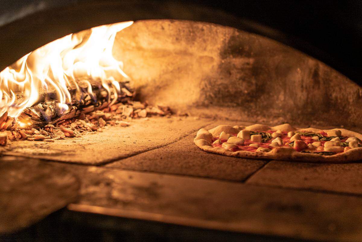 A Proof pizza slides into the wood fired oven. Heaven? Maybe.