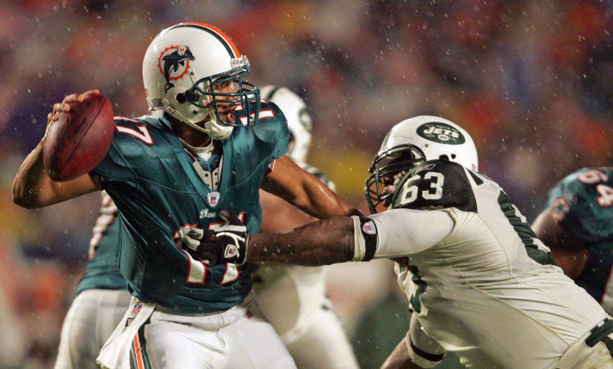 Dolphins quarterback Cleo Lemon throws under pressure from Jets defensive tackle Dewayne Robertson during the third quarter in a game on Dec. 25, 2006.