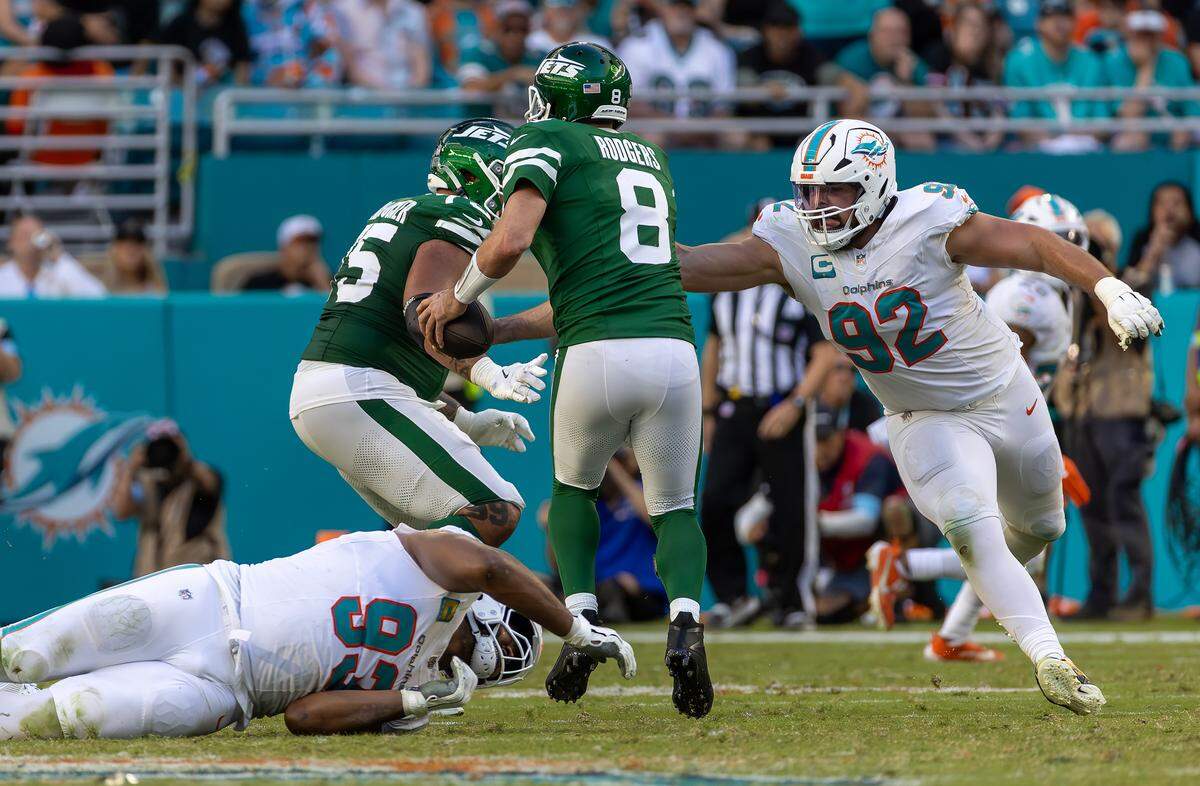 Miami Dolphins defensive tackles Zach Sieler (92) and Calais Campbell (93) sack New York Jets quarterback Aaron Rodgers (8) during the second half of their NFL game at Hard Rock Stadium on Sunday, Dec. 8, 2024, in Miami Gardens, Florida.