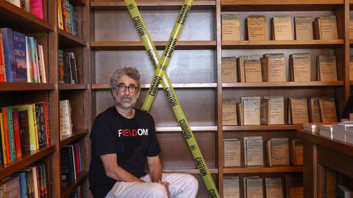 Books and Books owner Mitch Kaplan sits near empty book shelves to illustrate the effects of Florida’s book bans during a “Freadom” event in Coral Gables.