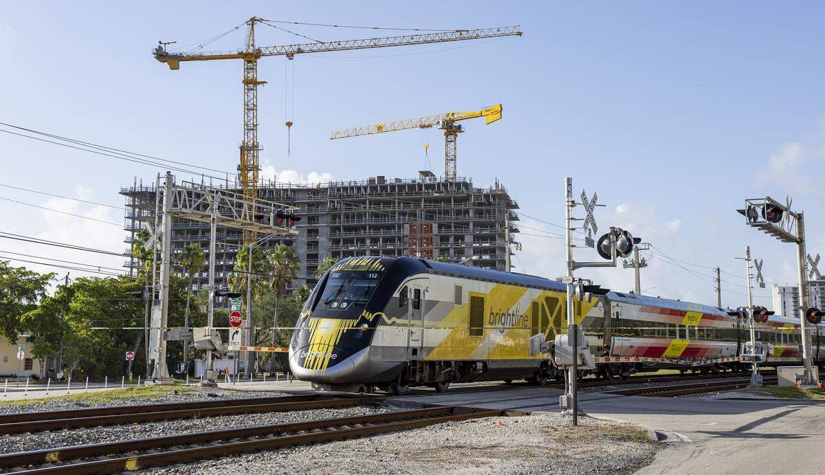 A Brightline train crosses through Northeast 141st Street near Biscayne Boulevard in North Miami. The crossing has “quad gates,” or four gates, preventing drivers from going around. Such sealed crossings are required for higher-speed trains in a set of new rail crossing regulations that go into effect in January.