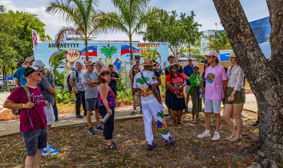 Jean Dondy Cidelca (center) leads a group of people on Saturday May 18, 2025 during a HistoryMiami Museum Little Haiti History and Culture Walk where he talked about the celebration of Haiti’s Flag Day on May 18.