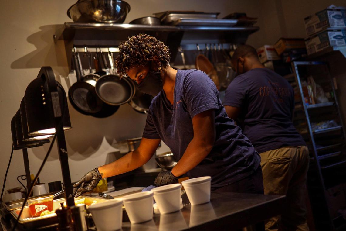Jamila Ross, left, and Akino West, right, work in their small kitchen, making chicken and waffles at for their pop-up restaurant Rosie’s Cafe. They are also cooking for volunteers at the nearby Overtown restaurant, Red Rooster, as part of José Andrés World Central Kitchen. Their 22-room Overtown bed and breakfast is closed due to the coronavirus pandemic.