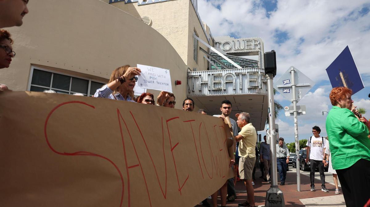 Varias personas con un cartel que dice "Save Tower" afuera del Tower Theater durante la protesta por la salida del Miami-Dade College como su operador, el 4 de octubre de 2022 en La Pequeña Habana.