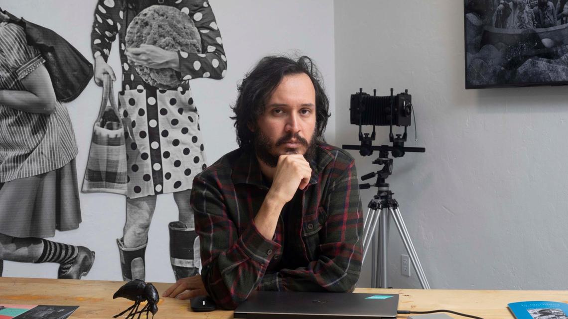 Artist Edison Peñafiel in front of his art (L) Land Escape Site-specific Installation: Digital print on cotton paper 2019 and (R) MARE MAGNVM_Single channel video 2022, in his studio, at Oolite Arts in Lincoln Road, South Beach on Friday March 11th., 2022.