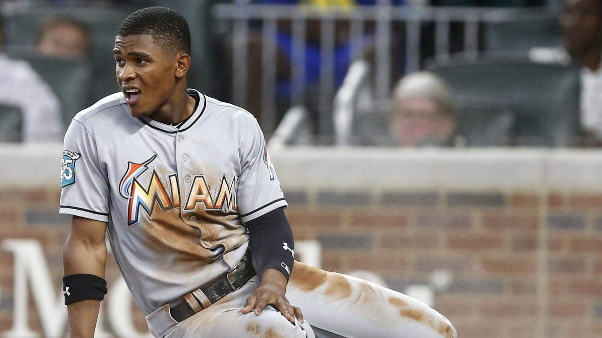 ATLANTA, GA - AUGUST 14:  Centerfielder Magneuris Sierra #34 of the Miami Marlins sits on home plate in a cloud of dust after scoring in the sixth inning during the game against the Atlanta Braves at SunTrust Park on August 14, 2018 in Atlanta, Georgia.  (Photo by Mike Zarrilli/Getty Images)