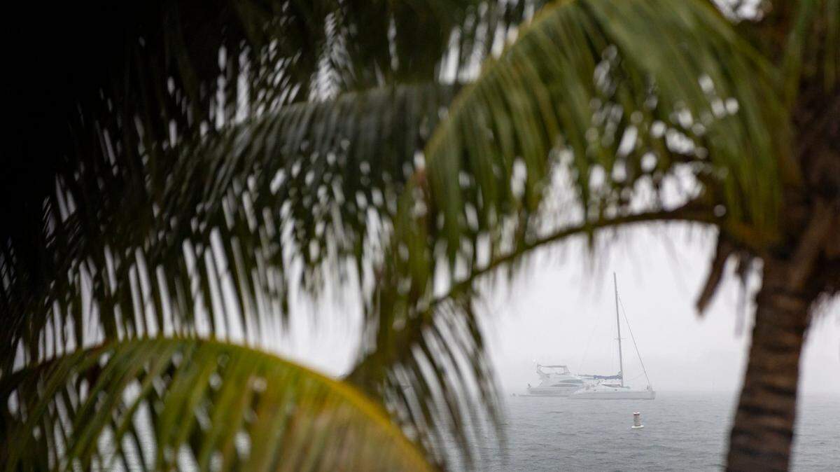 Boats can be seen near Hobie Island Beach Park as lightning and heavy rain falls in the area on Monday, June 19, 2023, in Miami, Fla.