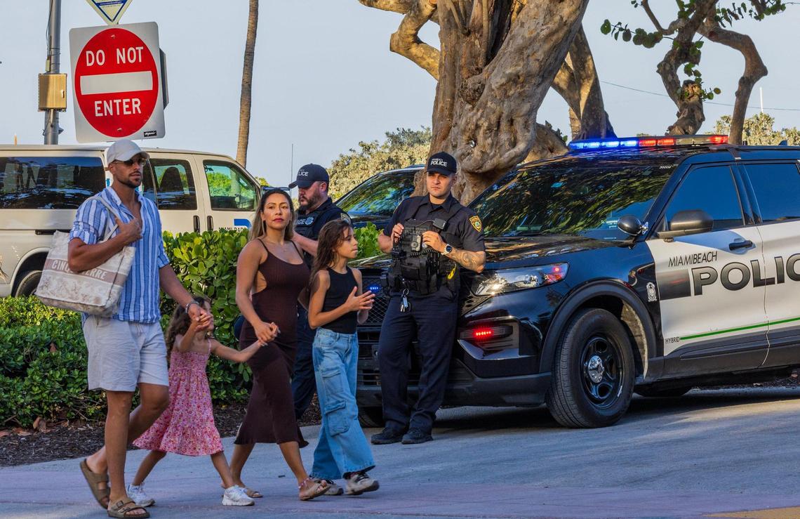 A family walk by a couple of Miami Beach Police Officers on patrol on Ocean Drive, during spring break, in Miami Beach, Florida. on Saturday March 22, 2025.